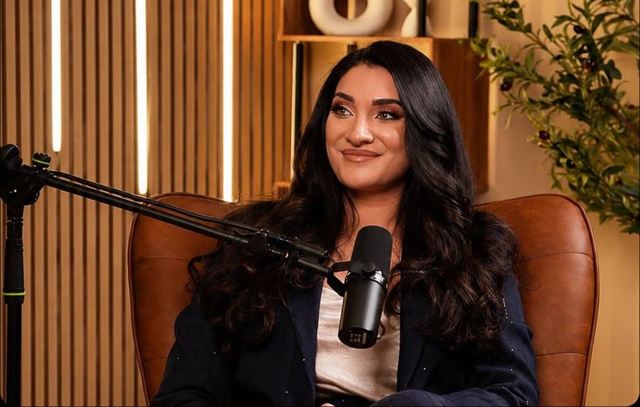 Guest smiling during a podcast recording on the leather armchair set