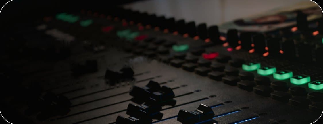 Studio audio mixing console with glowing faders